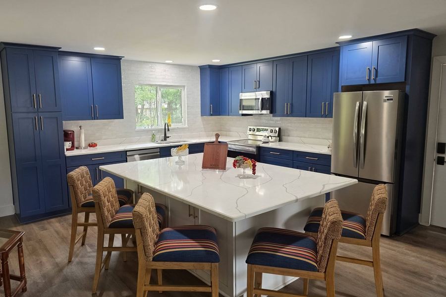 Remodeled kitchen with navy cabinets and a large quartz island